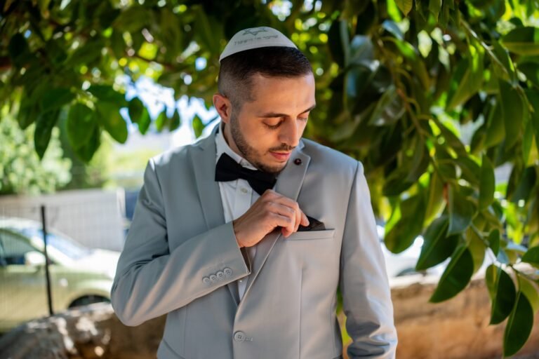 החתן מסדר את הפפיון לפני הטקס