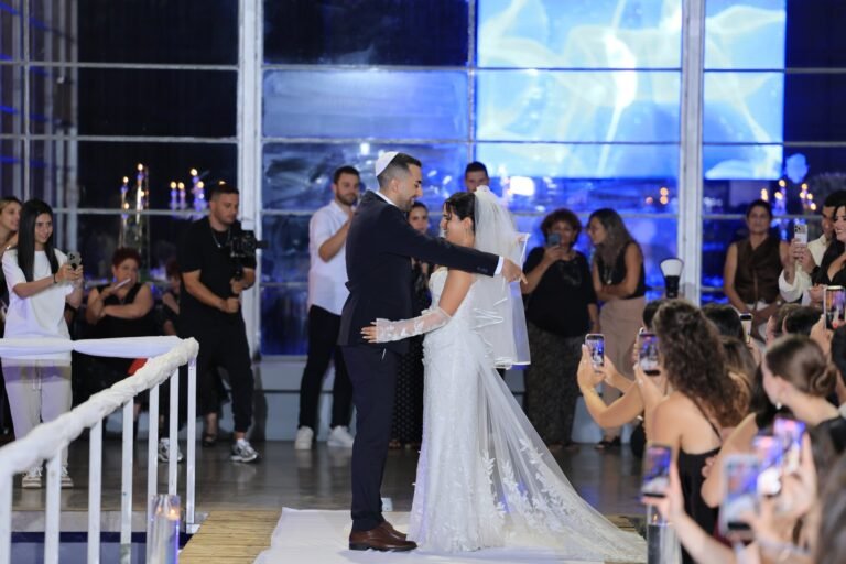 כניסת הכלה לחופה על רקע קיר תאורה כחול