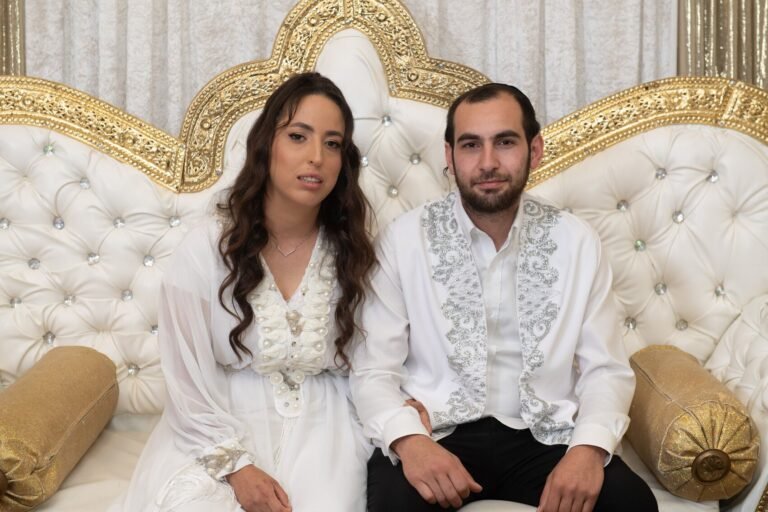 הזוג בלבוש חינה מסורתי על כס מוזהב